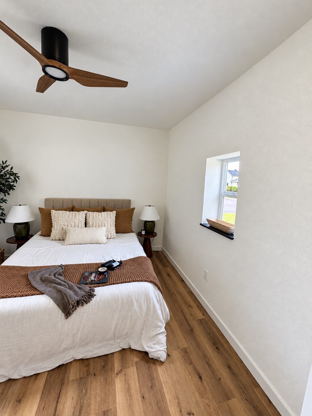 The finished bedroom under the sloped ceiling, with the window on the right and a furnished bed wall